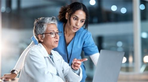 A nurse and doctor looking at a laptop