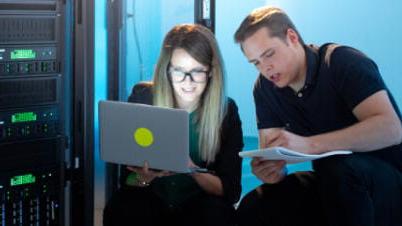 a man and a woman looking at a laptop