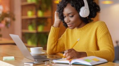 a women with headphones working on a laptop